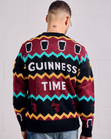 Person wearing a colorful sweater with 'Guinness Time' text on a plain background