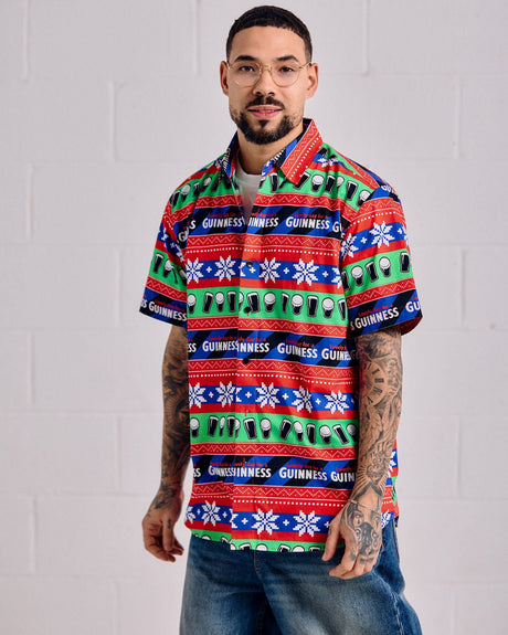 Man wearing a colorful patterned shirt with visible branding against a white background