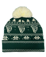 Green knit beanie with white patterns and pom-pom on a white background