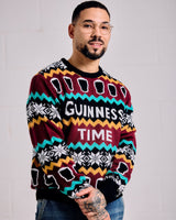 Person wearing a colorful sweater with 'Guinness Time' text against a plain background
