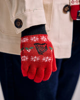 Red knitted glove with snowflake pattern held by a person wearing a beige coat.