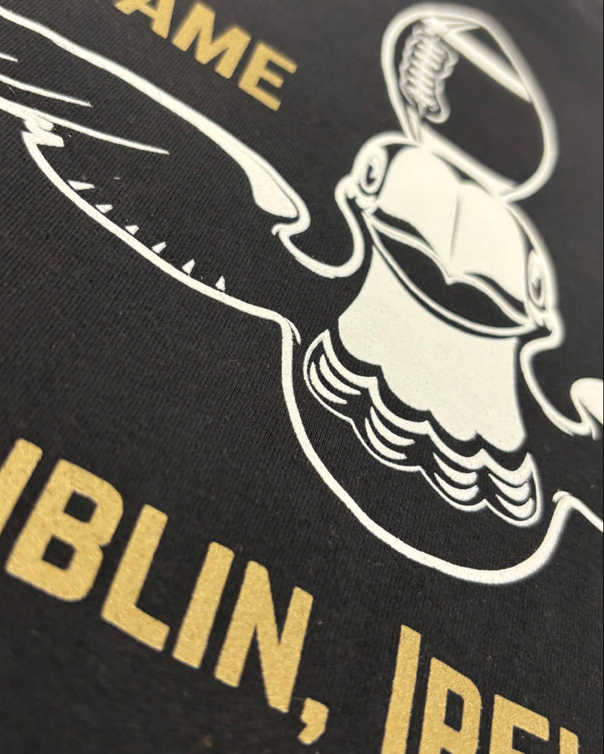Black shirt with white graphic of a leprechaun and gold text 'DUBLIN, IRELAND'.