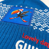 Blue knitted item with a colorful bird patch and 'Lovely day' text.