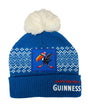 Blue knit beanie with white pom-pom, Guinness logo, and text on a white background