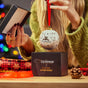 Image of girl opening up a Guinness Ceramic Christmas Bauble from its gift box