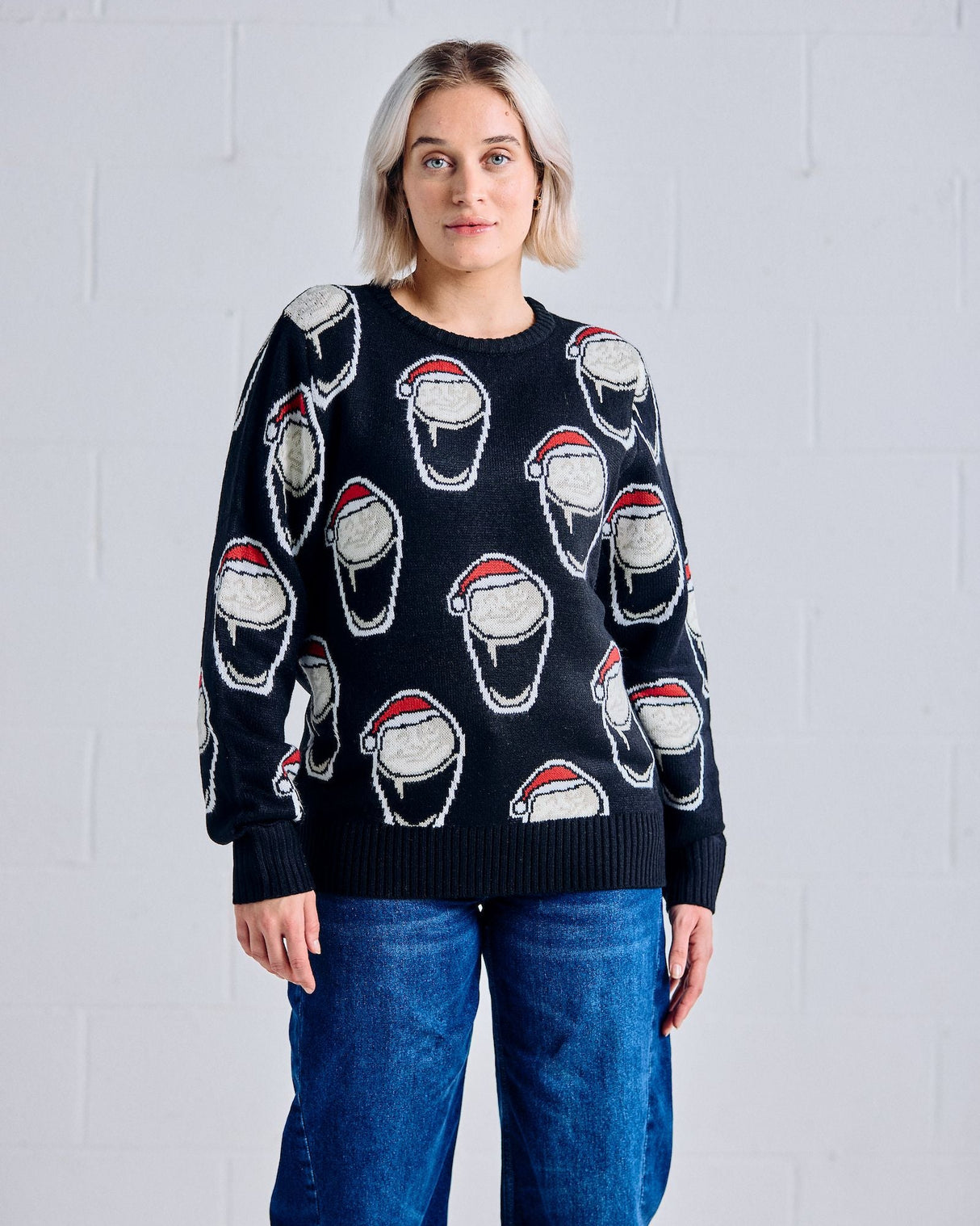 Person wearing a black sweater with white graphic designs on a light gray background
