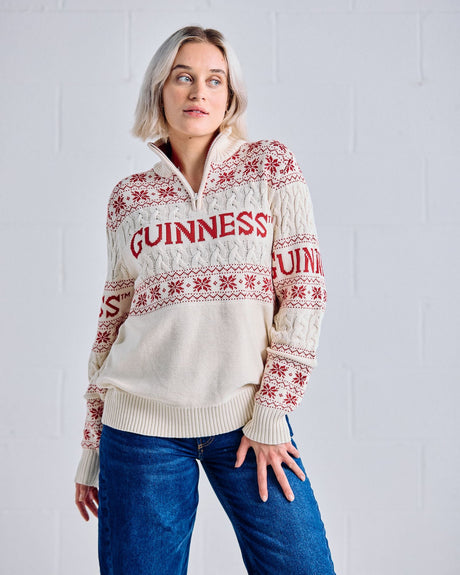 Person wearing a cream Guinness sweater with red patterns against a white background