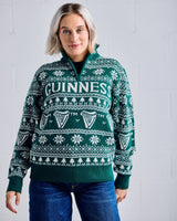 Woman wearing a green Guinness sweater with a white pattern against a light gray background