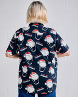 Person wearing a navy blue shirt with Guinness logo and Santa hats on a plain background