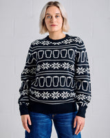 Person wearing a black sweater with white patterns against a gray background