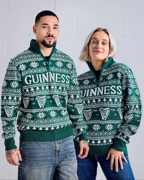 Two people wearing green Guinness sweaters against a light gray background