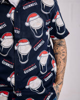 Navy blue shirt with Guinness beer and Santa hats pattern on a plain background