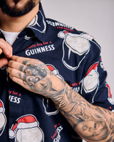 Navy blue shirt with white beer mug graphics and 'Guinness' branding, worn by a person with tattoos.