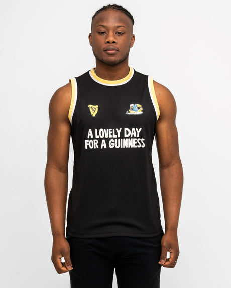 Person wearing a black sleeveless shirt with text and shorts on a white background