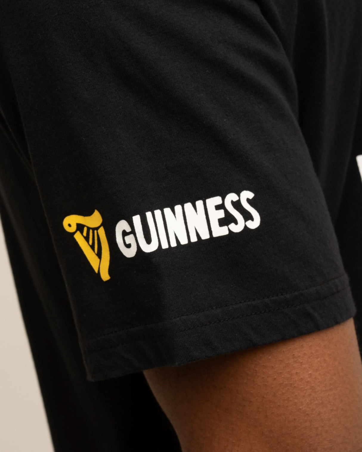 Black t-shirt with Guinness logo on a person wearing it.