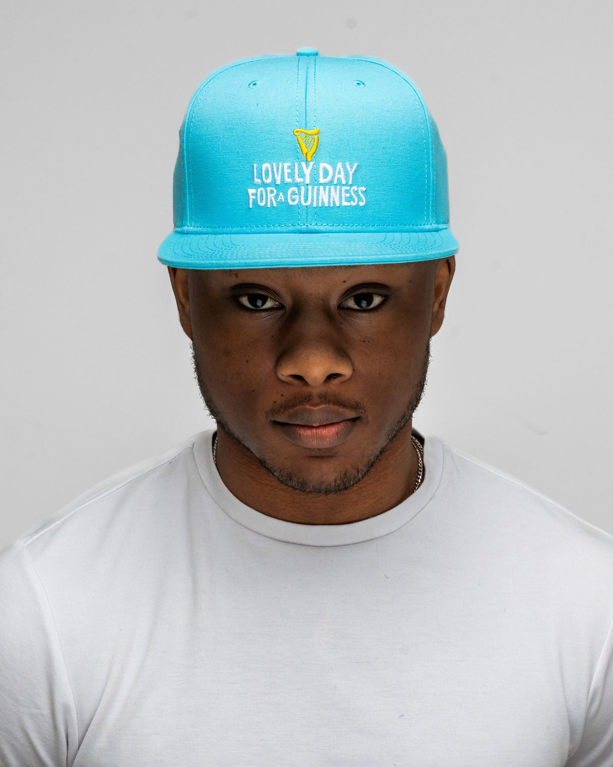 Person wearing a blue cap with text on a plain background