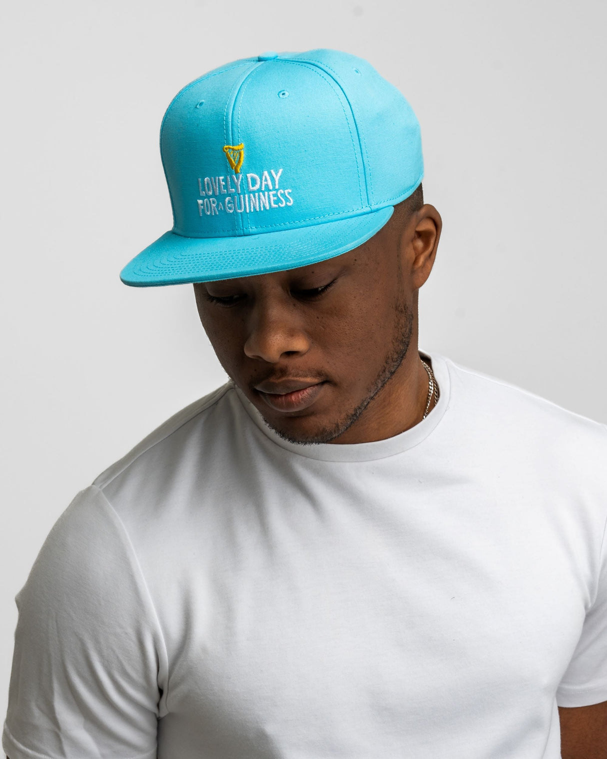 Man wearing a blue cap with text on a plain background