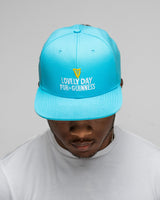 Person wearing a blue cap with 'Lovely Day for Guinness' text on a gray background