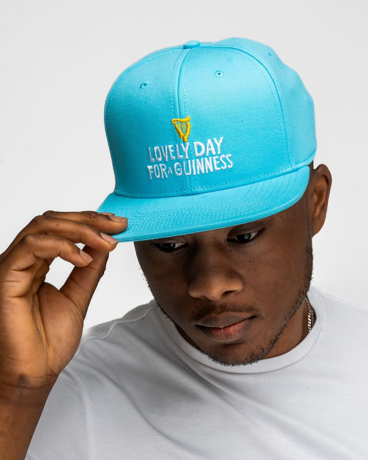 Person wearing a blue cap with 'Lovely Day for Guinness' text on a white background