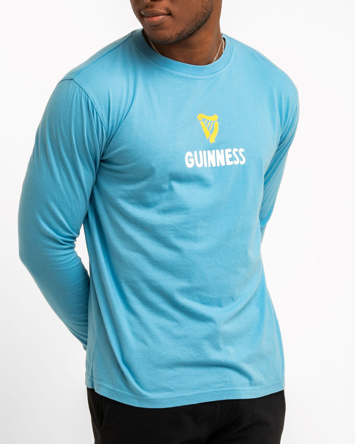 Person wearing a blue Guinness t-shirt on a white background