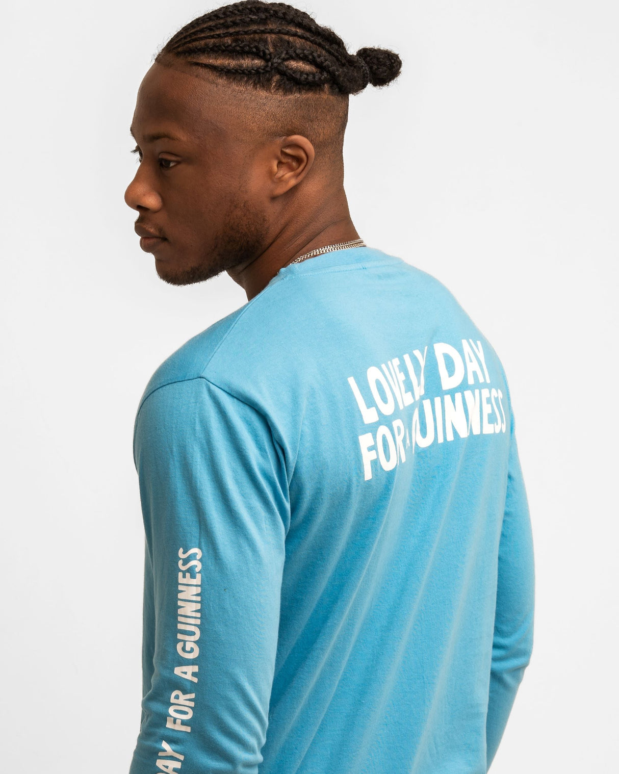 Person wearing a blue long-sleeve shirt with 'Lovely Day for a Guinness' text on a white background