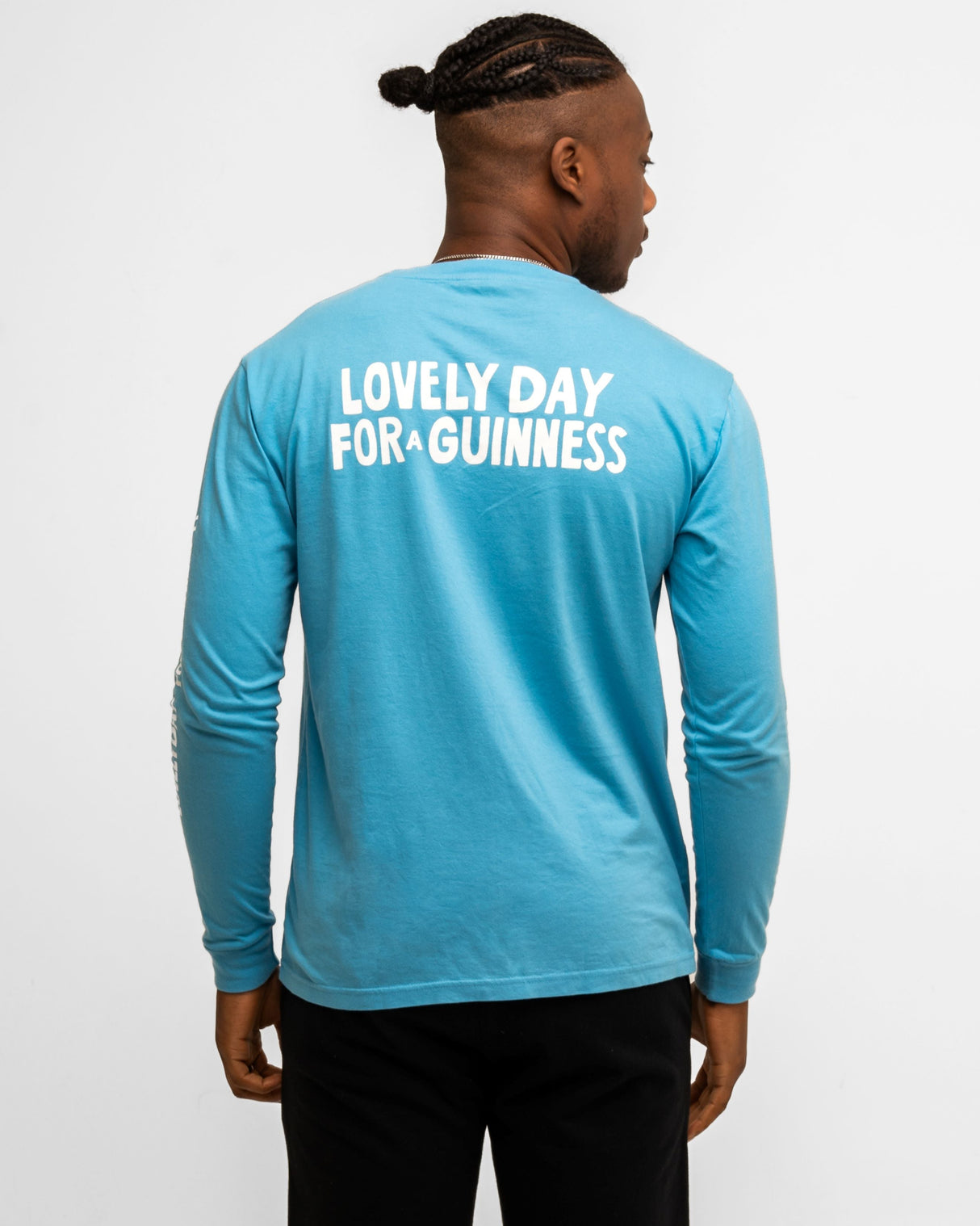 Person wearing a blue long-sleeve shirt with 'Lovely Day for Guinness' text on the back.