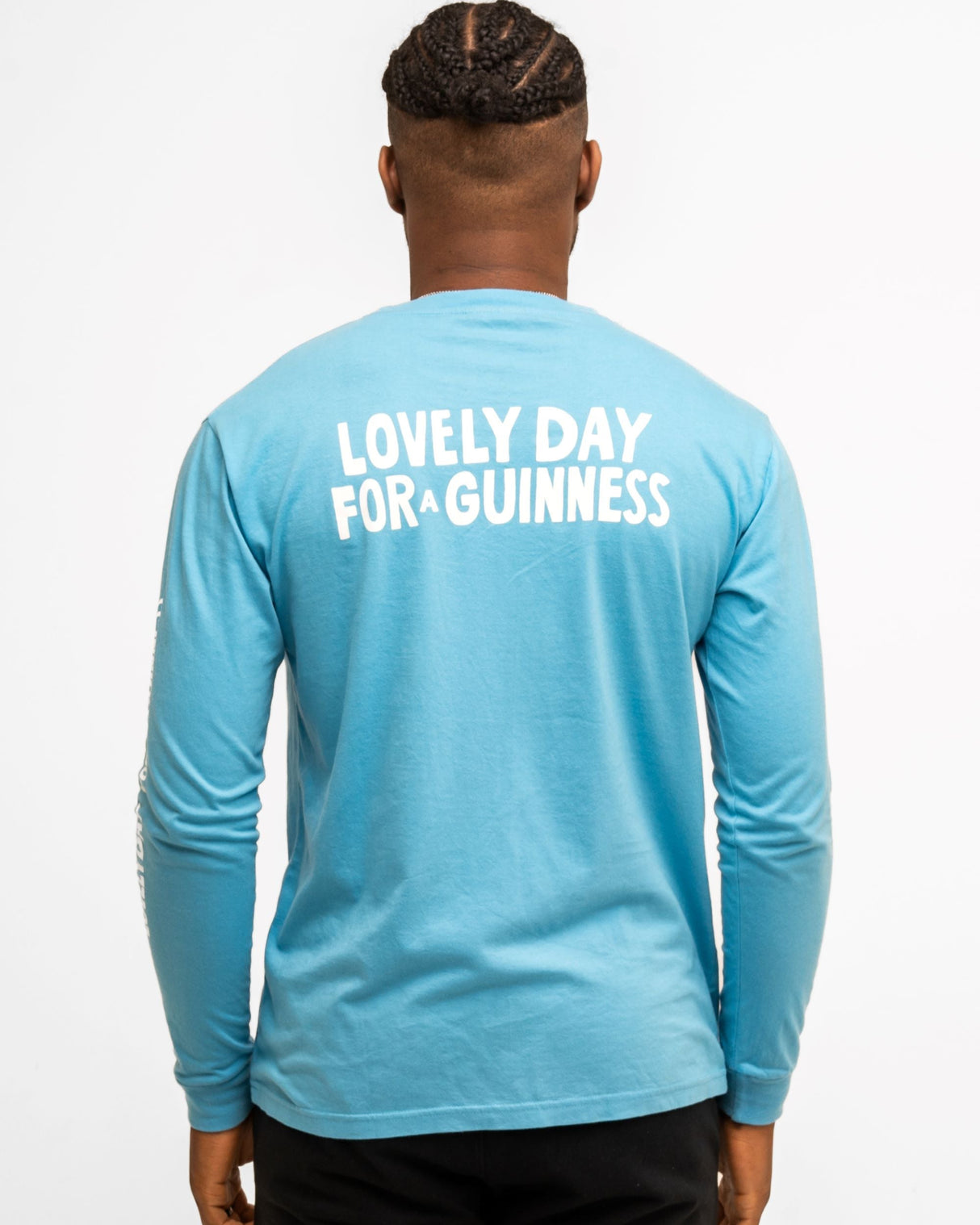 Person wearing a blue long-sleeve shirt with 'Lovely Day for a Guinness' text on the back.