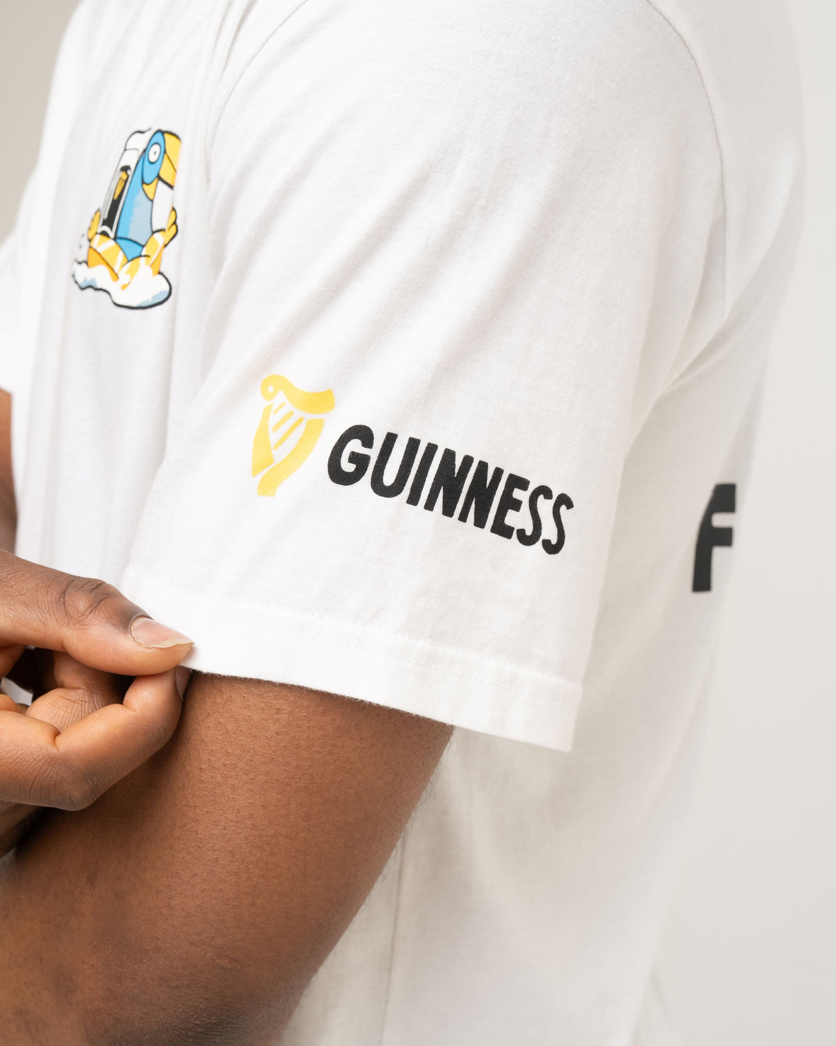 White t-shirt with Guinness logo on a person's arm