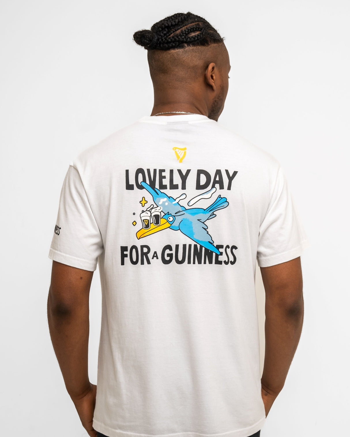 Person wearing a white t-shirt with 'Lovely Day for a Guinness' text and graphic on the back.