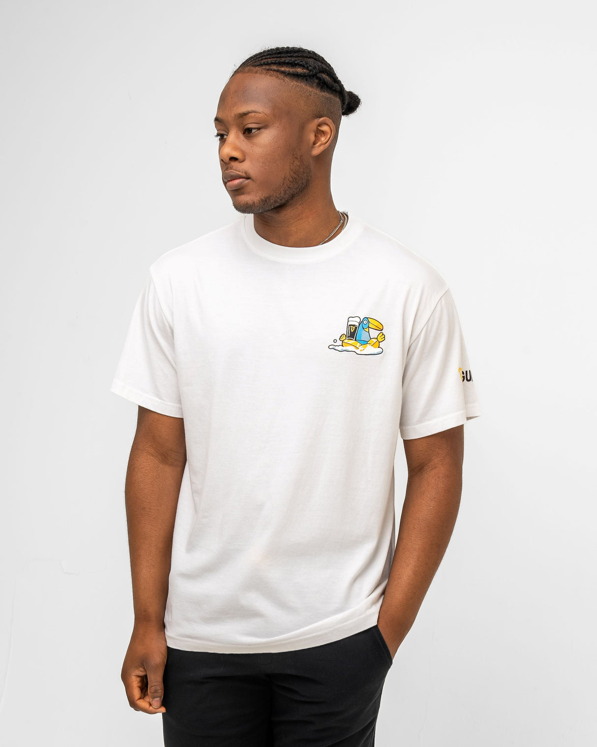 Man wearing a white t-shirt and black shorts with logos on a plain background
