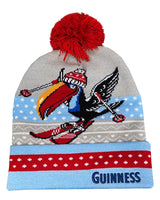 Knitted beanie with a red pom-pom, colorful design, and 'Guinness' branding on a white background.