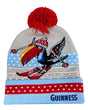 Knitted beanie with a red pom-pom, colorful design, and 'Guinness' branding on a white background.