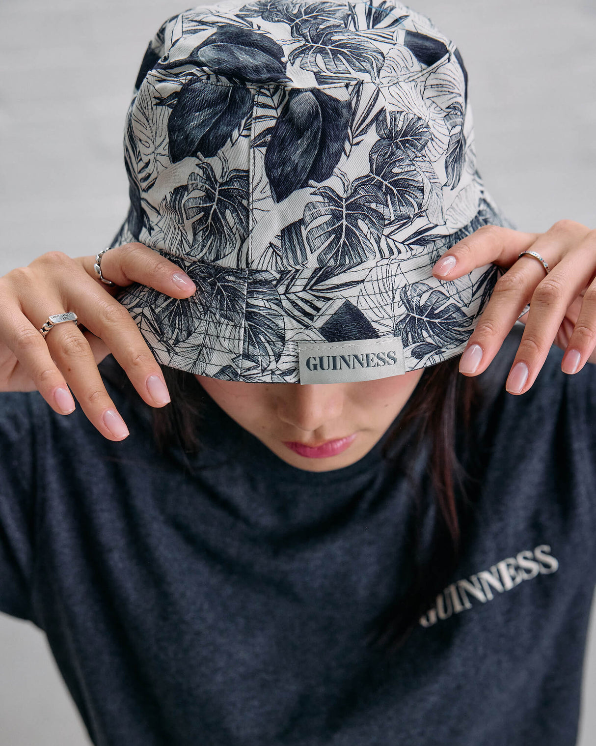 Person wearing a floral-patterned bucket hat and a black Guinness t-shirt.