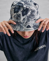 Person wearing a floral-patterned bucket hat and a black Guinness t-shirt.