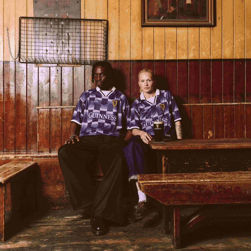 Image of guy and girl wearing Guinness x Art of Football jerseys in a Dublin pub.