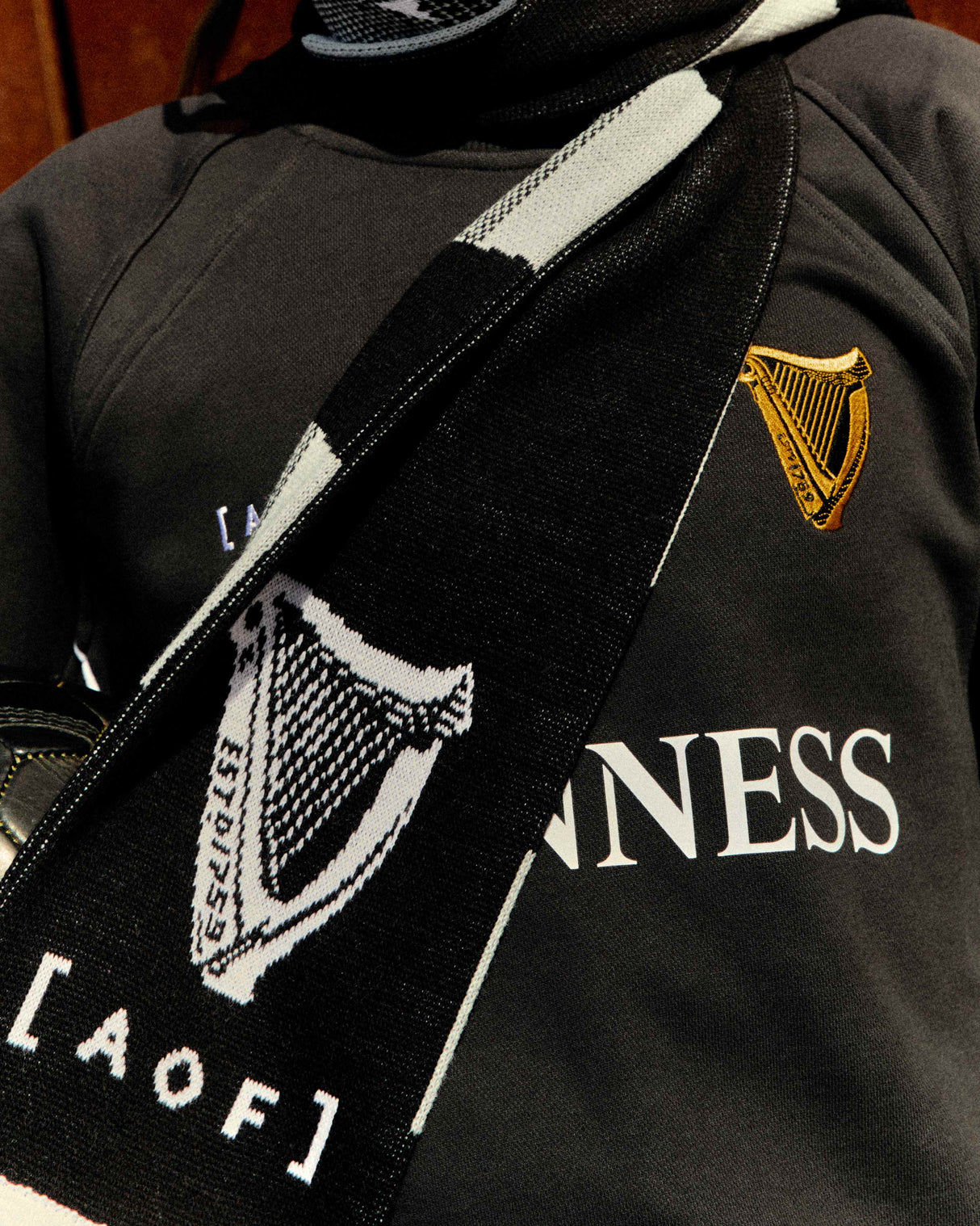 Black sweater with Guinness logo and text worn by a person