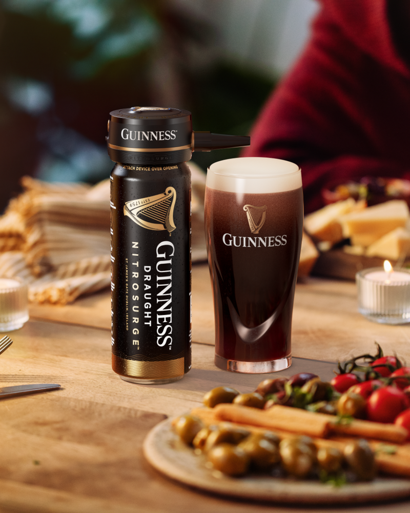 A can of Guinness nitrosurge with nitrosurge device and a pint of Guinness on a food table