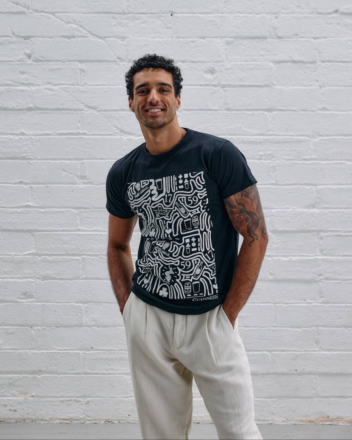 Model wearing the Guinness Storehouse Exclusive black t-shirt with stylized Dublin map.