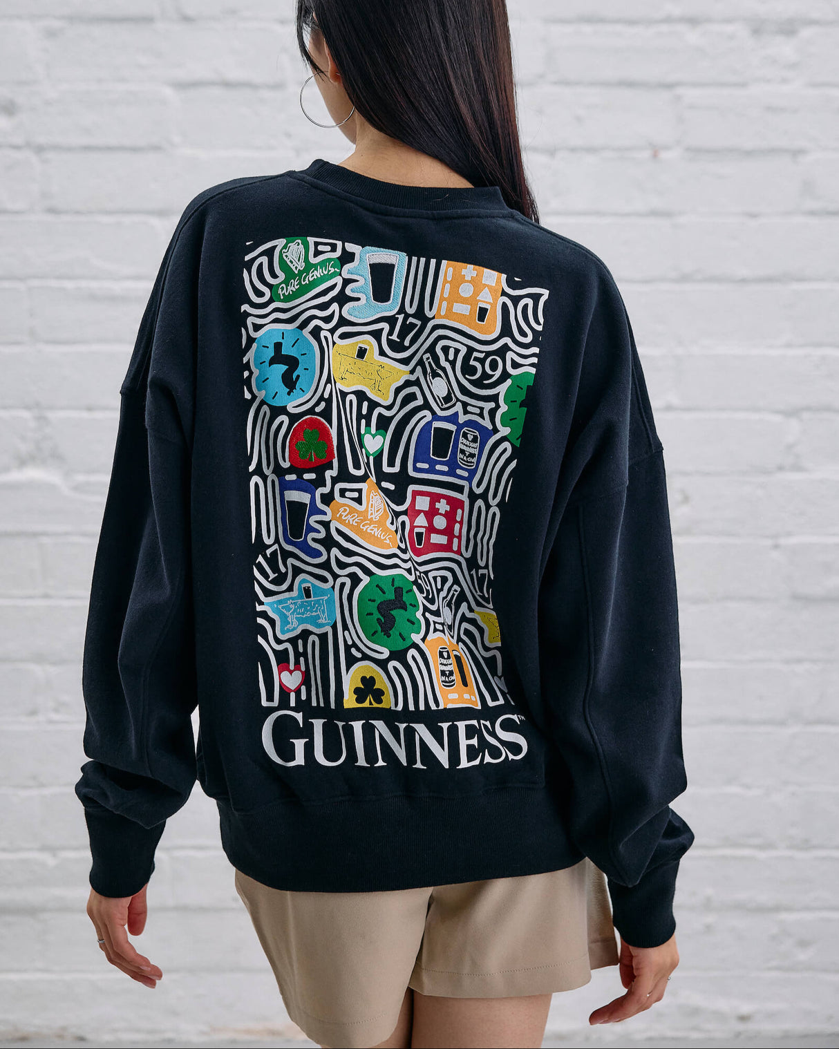 Model wearing the Guinness Storehouse Exclusive Black Sweter with stylized Dublin map.