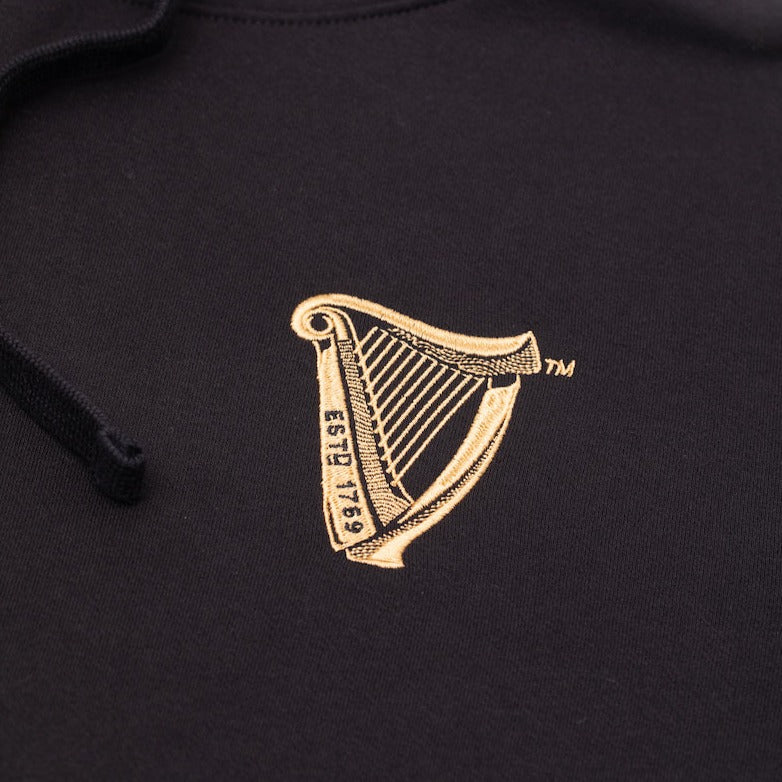 Detail of the Guinness Storehouse Exclusive black hoodie iconic Guinness Harp logo.