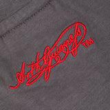 Detail of the Guinness Storehouse Exclusive dark grey t-shirt's  Arthur Guinness red signature. 